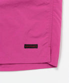 Bright plum colored Gramicci Nylon Packable G-Short hem showing the logo label on a light-tone background.