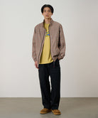 Model wearing black Gramicci EQT Pant and a plaid jacket on a light-tone background.