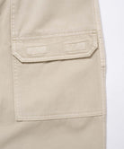Close-up view of sand pigment Gramicci EQT Pant pocket detail on a light-tone background.