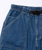 Close-up view of light wash colored Gramicci Denim EQT Pant on a light-tone background.