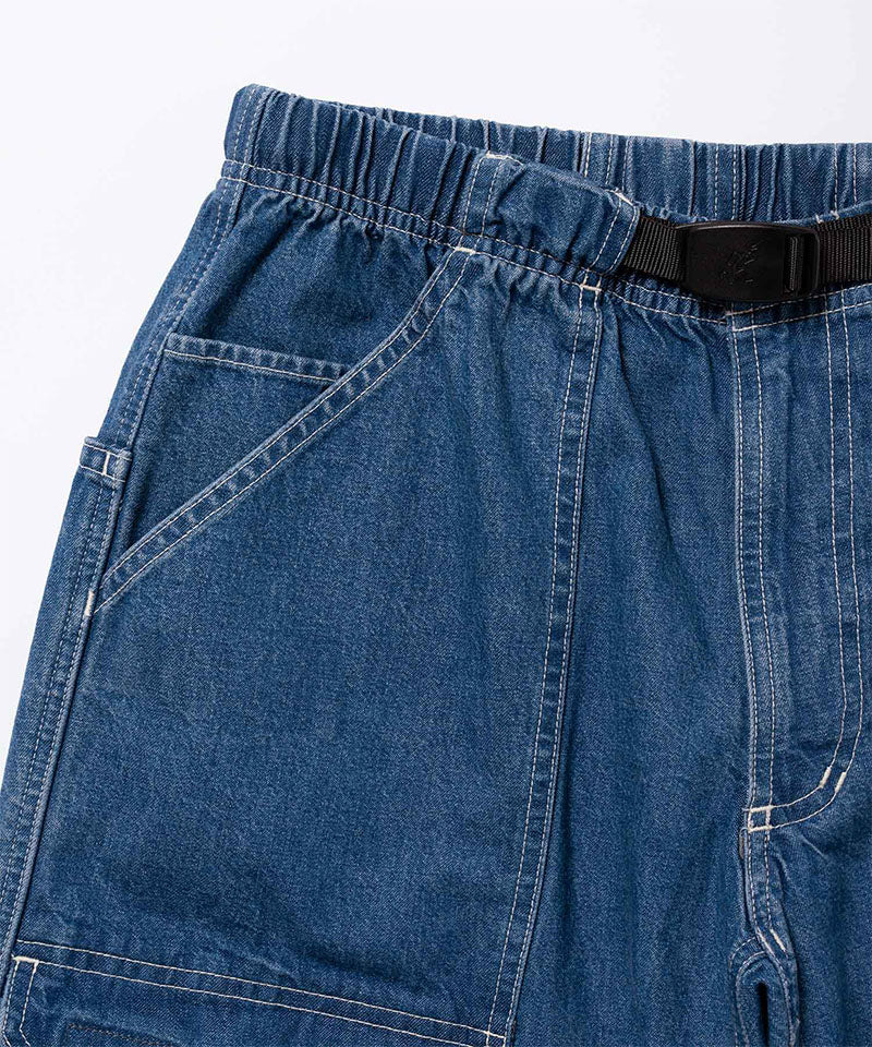Close-up view of light wash colored Gramicci Denim EQT Pant on a light-tone background.