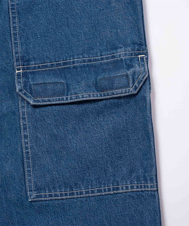 Close-up view of light wash colored Gramicci Denim EQT Pant pocket detail on a light-tone background.