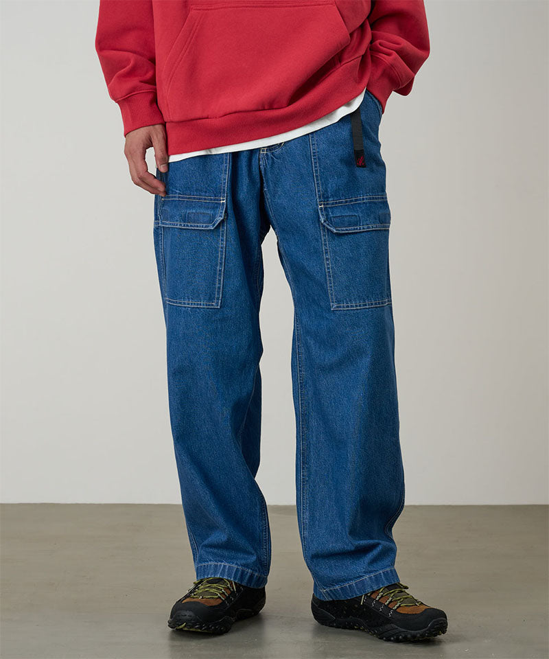 Model wearing light wash colored Gramicci Denim EQT Pant and a red hoodie on a light-tone background.