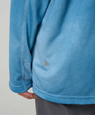 Close-up view of a Gramicci L/S 1st Layer in blue tie-dye on a light-tone background.