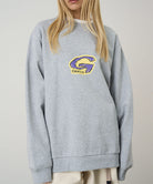 Model wearing a Gramicci heather grey G-Scribble Sweatshirt with purple and yellow graphic against a light tone background.