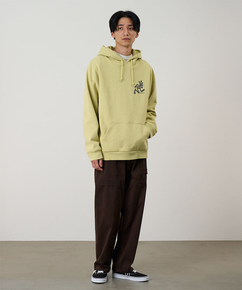 Model wearing a lime Gramicci Running Man Hooded Sweatshirt with a grey running man graphic and brown pants on a light tone background.