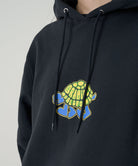 Model wearing a Gramicci vintage black Turtle Hooded Sweatshirt with turtle graphic against a light tone background.