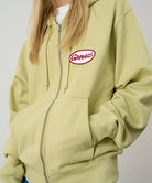 Light green hoodie with a red and white logo on a plain background