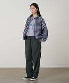 Model wearing shadow colored Gramicci Swell Pant and a plaid jacket on a light-tone background.