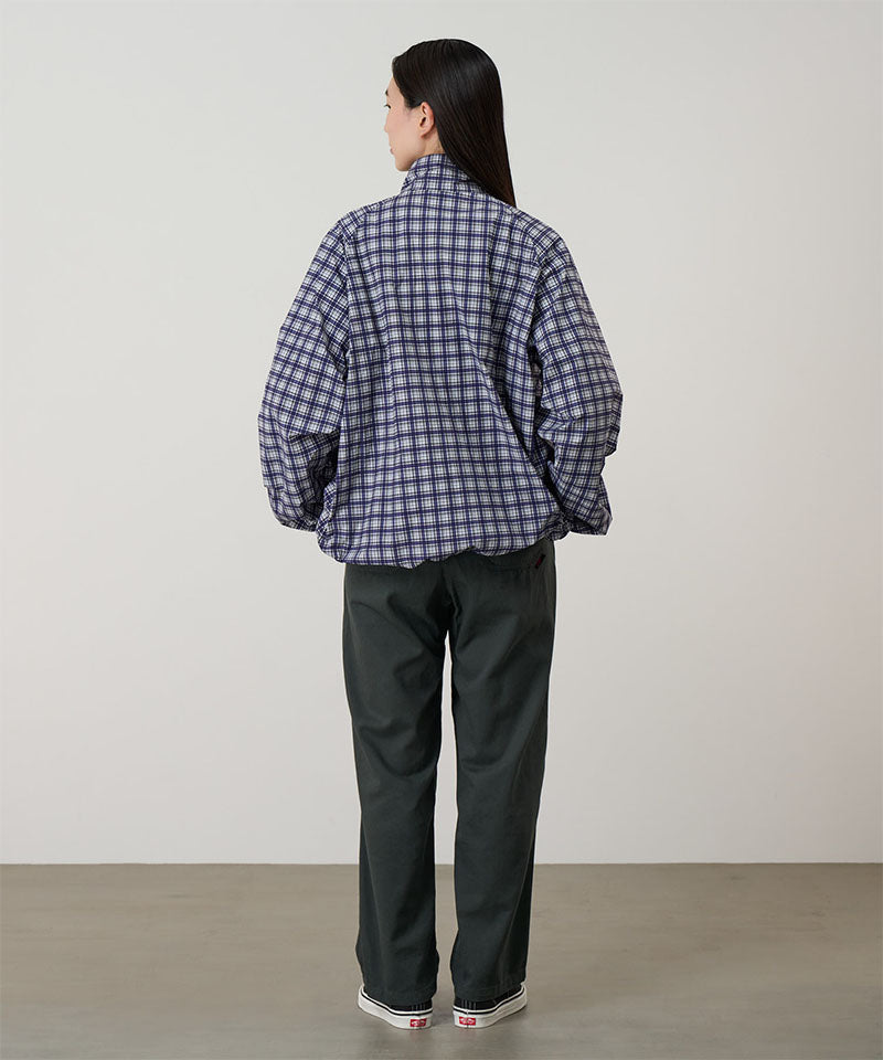 Back view of a model wearing shadow colored Gramicci Swell Pant and a plaid jacket on a light-tone background.