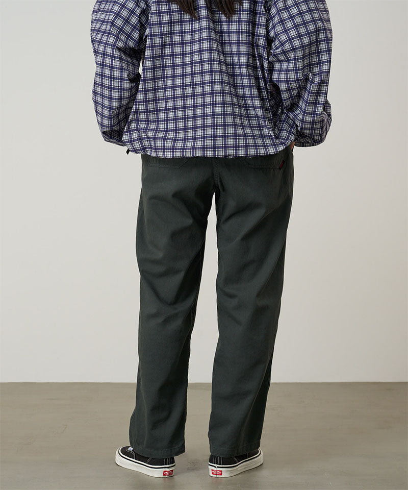 Back view of a model wearing shadow colored Gramicci Swell Pant and a plaid jacket on a light-tone background.