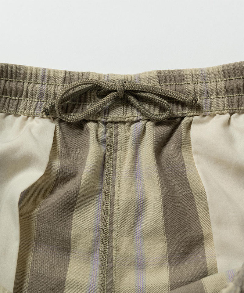 Close-up inside view of shadow plaid colored Gramicci Swell Short Shadow Plaid with drawstring detail on a light-tone background.