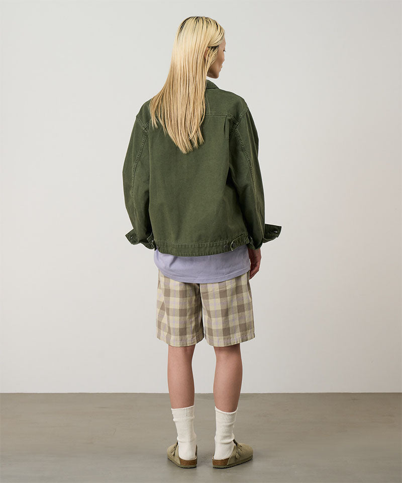 Back view of a model wearing shadow plaid colored Gramicci Swell Short Shadow Plaid and a olive jacket on a light-tone background.