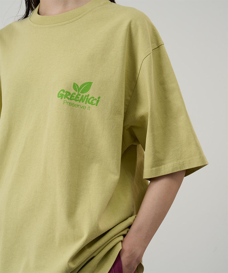Model wearing a Gramicci lime Greenicci Tee with a graphic against a light tone background.
