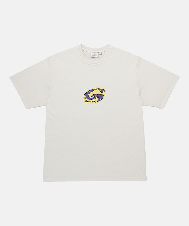 Gramicci natural colored G-Scribble Tee Pigment Dyed shirt with a purple graphic against a light tone background.
