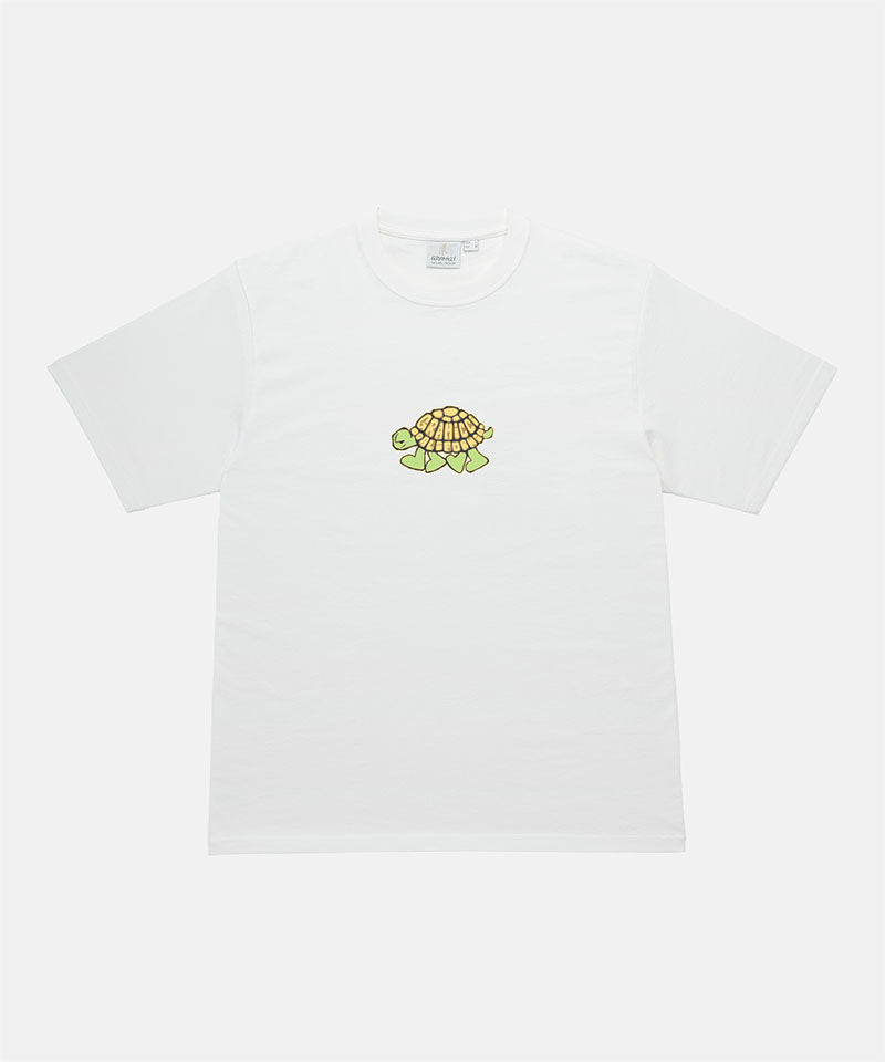 Gramicci white Turtle Tee with a turtle graphic against a light tone background.
