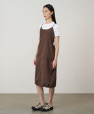 Model wearing a Gramicci Women's Woven Milton Dress in the color walnut and a white undershirt on a light-tone background.

