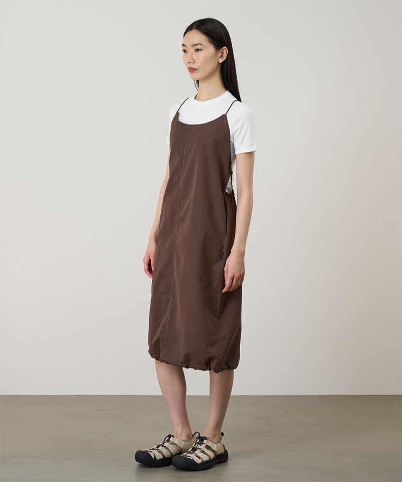 Model wearing a Gramicci Women's Woven Milton Dress in the color walnut and a white undershirt on a light-tone background.
