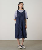 Model wearing a british navy colored Gramicci Nylon Dress and a lavender shirt on a light-tone background.