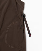 Close-up view of a chocolate colored Gramicci Nylon Dress against a light-tone background.