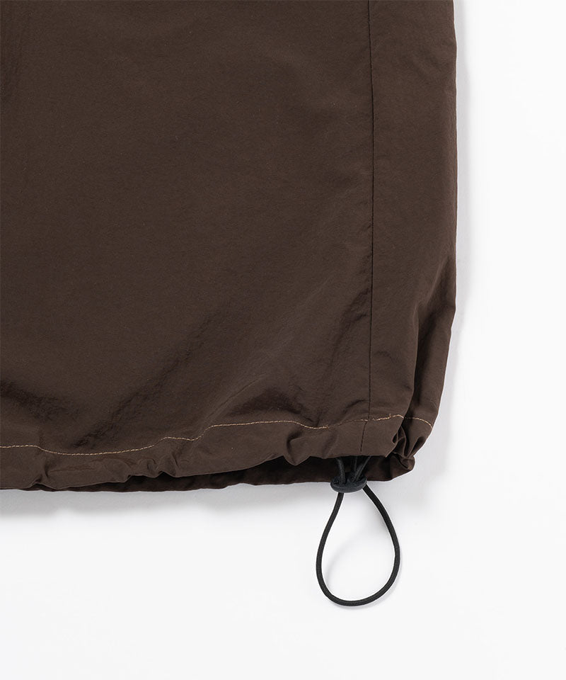 Chocolate colored Gramicci Nylon Dress hem with drawstring on a light-tone background.