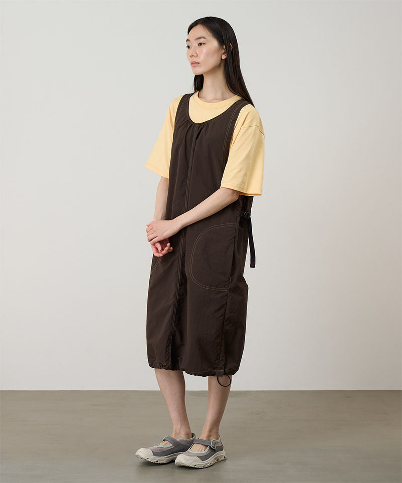 Model wearing a chocolate colored Gramicci Nylon Dress and a yellow shirt on a light-tone background.