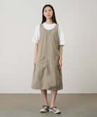 Model wearing a milk tea colored Gramicci Nylon Dress and a white shirt on a light-tone background.