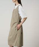 Model wearing a milk tea colored Gramicci Nylon Dress and a white shirt on a light-tone background.