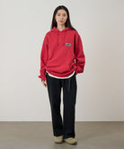 Model wearing black Gramicci Women's Brooks Pants and a red hoodie on a light-tone background.