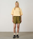 Model wearing artichoke Gramicci Women's Nylon Active Short and a yellow shirt on a light-tone background.
