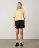 Model wearing black Gramicci Women's Nylon Active Short and a yellow shirt on a light-tone background.