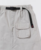 Close-up view of an ecru colored Gramicci Nylon Utility Skirt pocket and belt on a light-tone background.