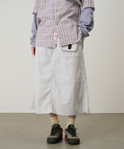 Back view of a model wearing a Gramicci ecru colored Nylon Utility Skirt against a light-tone background.