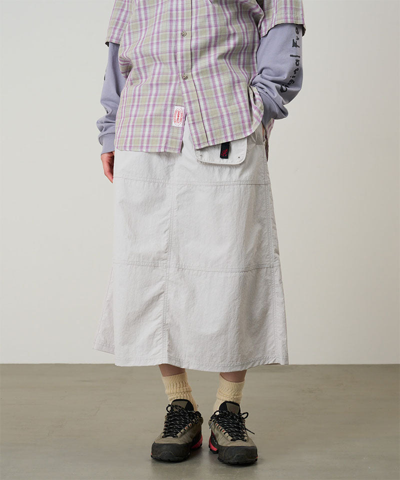 Back view of a model wearing a Gramicci ecru colored Nylon Utility Skirt against a light-tone background.