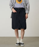Model wearing a Gramicci black Nylon Packable Midi Skirt against a light-tone background.