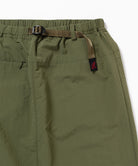 Close-up view of a olive Gramicci Nylon Packable Midi Skirt on a light-tone background.