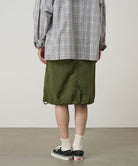 Back view of a model wearing a Gramicci olive Nylon Packable Midi Skirt against a light-tone background.