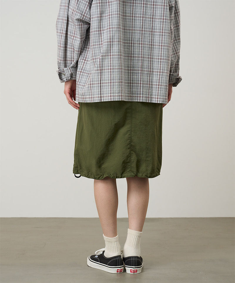 Back view of a model wearing a Gramicci olive Nylon Packable Midi Skirt against a light-tone background.