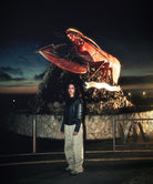 Person standing in front of a large lobster sculpture at night.