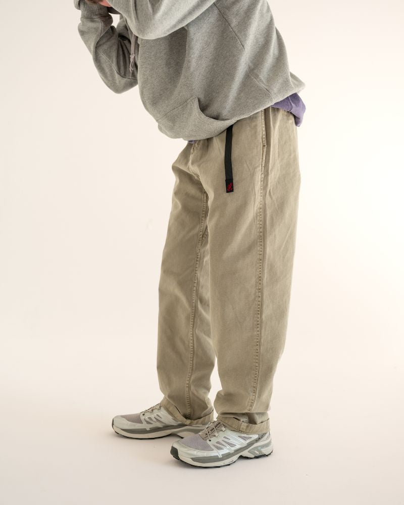 Person wearing a gray hoodie and beige Gramicci pants on a light background