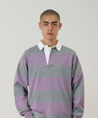 Model wearing a Gramicci heather and purple stripped Gramicci Langdon Rugby Shirt against a light-tone background.